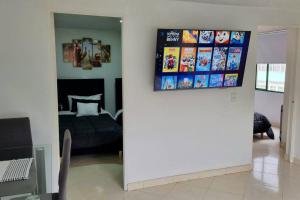 een kamer met een bed en een televisie aan de muur bij Luminoso y confortable apartamento a 6 min aeropuerto in Bogota