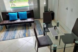 een woonkamer met een bank en een glazen tafel bij Luminoso y confortable apartamento a 6 min aeropuerto in Bogota