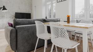 a living room with a couch and a table and chairs at VacationClub - Old Town Apartament 15 in Kłodzko