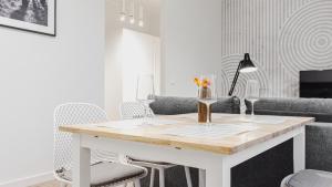 a white living room with a table and chairs at VacationClub - Old Town Apartament 15 in Kłodzko
