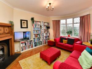 a living room with a red couch and a tv at Pass the Keys A home away from home in Cardiff