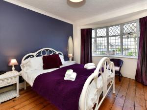 a bedroom with a white bed with a purple blanket at Pass the Keys A home away from home in Cardiff