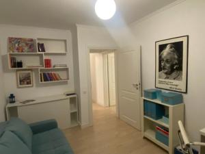 a living room with a blue couch and a book shelf at Fortuna Flat in Piteşti