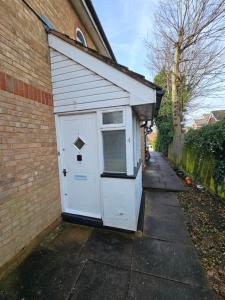 a white shed with a door on the side of a building at Harry Potter Hogwarts apartment in Leavesden Green