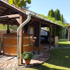 a wooden pergola with a hose coming out of it at Bóbita Apartmanház in Szilvásvárad