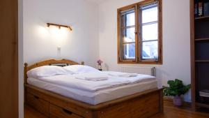 a bedroom with a bed with white sheets and a window at VacationClub - Cicha 8 Apartament 2 in Polanica-Zdrój