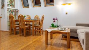 a living room with a table and chairs and a couch at VacationClub - Cicha 8 Apartament 2 in Polanica-Zdrój