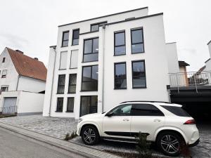un coche blanco estacionado frente a una casa blanca en Appartement Neugasse de Luxe en Bad Camberg