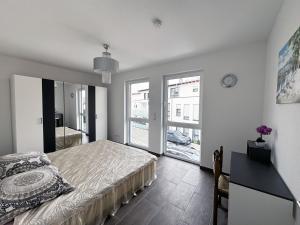 een slaapkamer met een bed en een groot raam bij Appartement Neugasse de Luxe in Bad Camberg