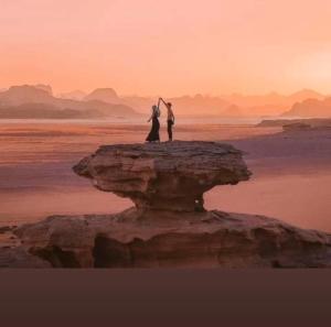 a couple standing on a rock in the ocean at Desert Life Camp in Wadi Rum