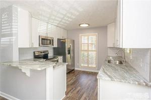 a kitchen with white cabinets and a counter top at Historic Haymount House with Tuscan Vibe in Fayetteville