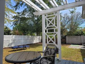 a table and chairs sitting under a white pergola at Historic Haymount House with Tuscan Vibe in Fayetteville