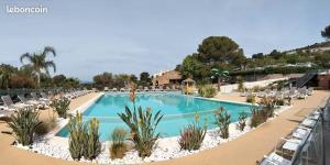 - une piscine avec des chaises longues et un complexe dans l'établissement Kabane Bohème à St-Raphael au Cap Estérel, à Saint-Raphaël