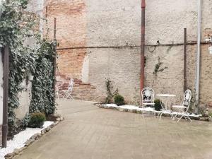 a patio with chairs and tables and a brick wall at Oldtownvilla apartament in Sibiu