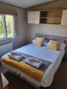 a bedroom with a large bed with two towels on it at Newquay Bay Porth Caravan - 6 berth in Newquay