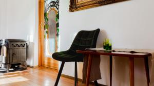 einem grünen Stuhl neben einem Tisch in einem Zimmer in der Unterkunft VacationClub - Cicha 8 Apartament 1 in Polanica-Zdrój