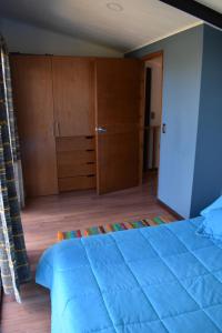 een slaapkamer met een groot blauw bed en houten kasten bij Posada Andalucia in Iza