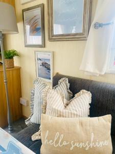 a living room with striped pillows on a couch at Shell Beach Holiday Home Mersea Coopers Beach in East Mersea