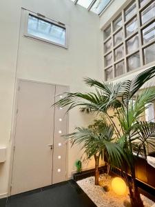 a room with two palm trees in front of a door at Maison Stylée 98m2 centre bordeaux in Bordeaux