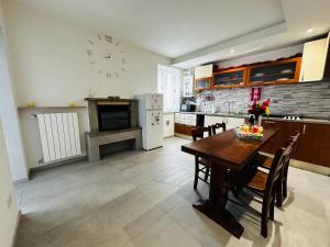 a kitchen with a table and a clock on the wall at La casa verde in Beccacivetta