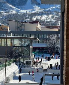a group of people skiing in the snow in a building at O oooo in Bakuriani
