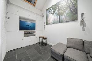 a living room with a couch and a flat screen tv at Glamorous 2BR House, Outdoor Space & Free Parking in London