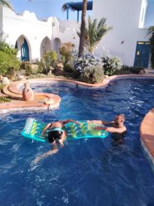 two people in the swimming pool at a resort at Dar Aladin in Arkou