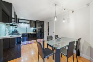 a dining room with a glass table and chairs at Glamorous 2BR House, Outdoor Space & Free Parking in London