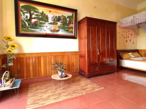1 dormitorio con 1 cama y una pintura en la pared en Wild Flower Homestay, en Ninh Binh