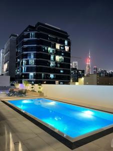 a swimming pool on the roof of a building at night at Diamond Jumeirah Garden City 1BR Apt in Dubai
