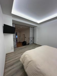 a bedroom with a bed and a television on the wall at Zeffirino Apartments in Sanremo
