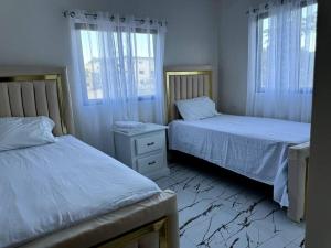 een slaapkamer met 2 bedden en 2 ramen bij Espectacular Villa En Alquiler in Las Terrenas