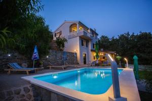 a swimming pool in front of a house at Holiday home in Omis with terrace, air conditioning, WiFi, washing machine 5202-1 in Omiš