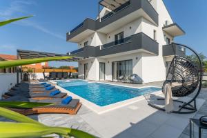 a villa with a swimming pool and a house at Holiday home in Bibinje with sea view, balcony, air conditioning, WiFi 5201-1 in Bibinje