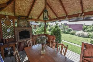 a dining room with a table and a fireplace at Vasarnamis Zarasuose - Vyšnia in Zarasai