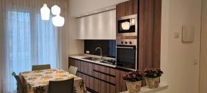 uma cozinha com uma mesa e uma cozinha com um lavatório e um fogão em Casa Mariettina em Sottomarina