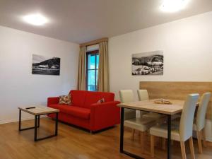 a living room with a red couch and a table at Apartmány NETA Velké Karlovice, Polanský Dvůr in Velké Karlovice