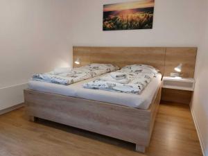 a bedroom with a large bed with a wooden headboard at Apartmány NETA Velké Karlovice, Polanský Dvůr in Velké Karlovice