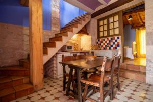 a kitchen with a wooden table and some stairs at Casa Rural Aldaba in Alcalá del Júcar
