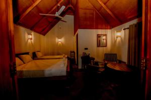 um quarto com uma cama e uma ventoinha de tecto em The Rainforest Hideaway em Deniyaya