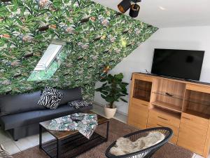 a living room with a couch and a tv at Noras Ferienwohnung 