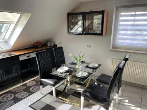 a dining room with a glass table and chairs at Noras Ferienwohnung 