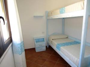 a bedroom with two bunk beds and a window at Appartamento in splendido e riservato villaggio, marina di Tertenia in Tertenìa