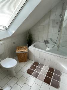 a bathroom with a toilet and a bath tub at Noras Ferienwohnung 