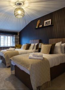 a bedroom with two beds and a chandelier at The Potting Shed in Chepstow