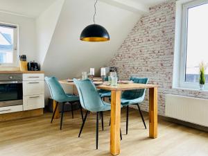 a dining room with a wooden table and blue chairs at DECK 7 - Wangerooge in Wangerooge