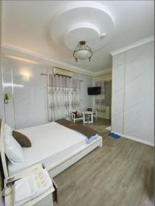 a bedroom with a large white bed and a tv at Khách Sạn An Chi in Ho Chi Minh City
