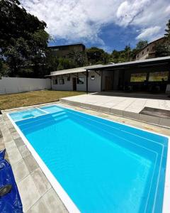 a large blue swimming pool in front of a house at Sítio com Piscina e Hidromassagem Confins in Confins