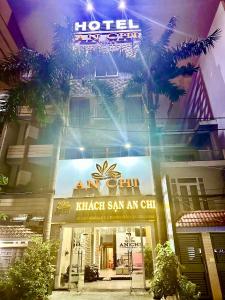 a hotel entrance with a palm tree in front of it at Khách Sạn An Chi in Ho Chi Minh City