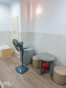 a bathroom with a blue fan and a table at Khách Sạn An Chi in Ho Chi Minh City
